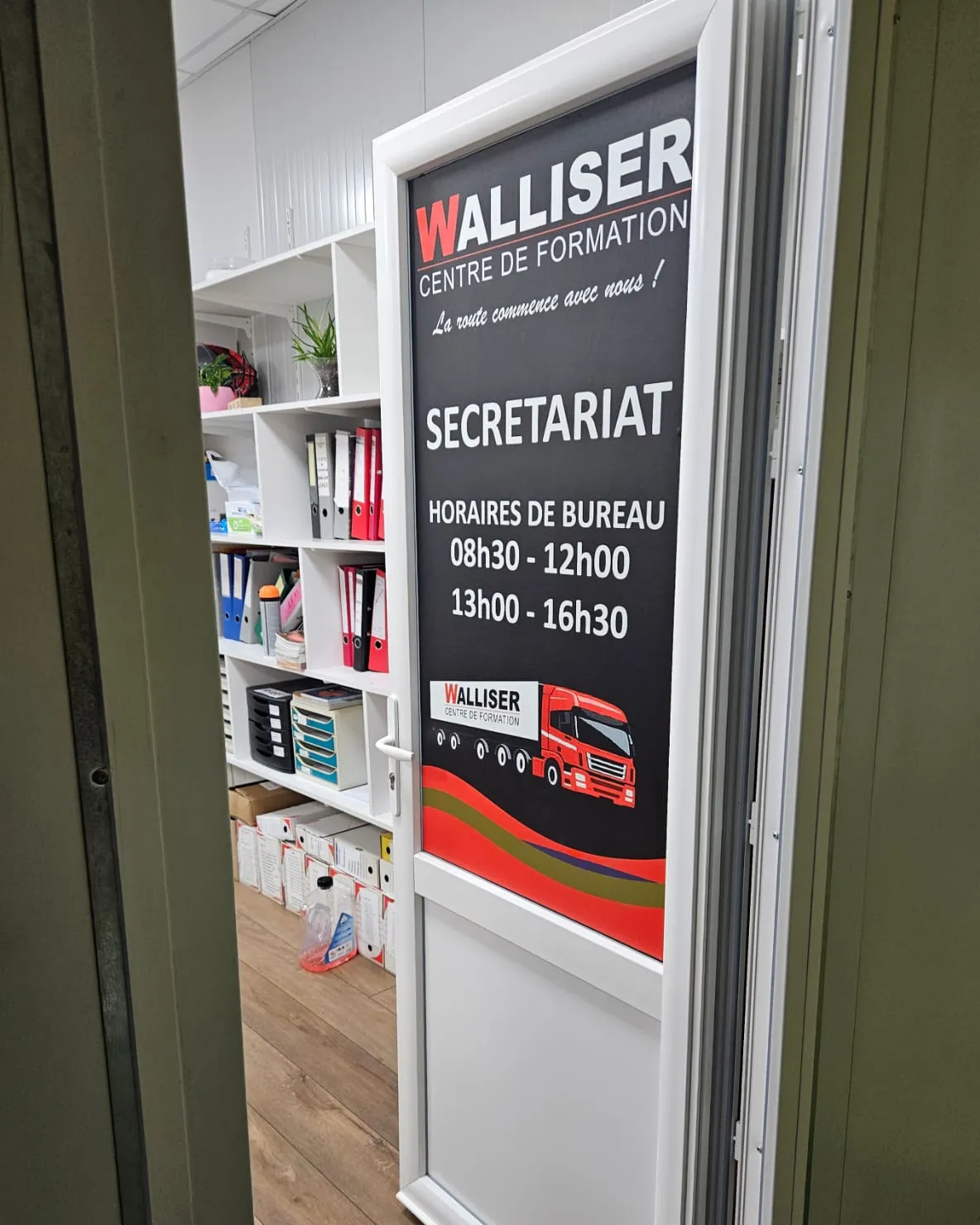 La porte du secrétariat, qui affiche les horaires de bureau : 08h30-12h00 et 13h00-16h30.